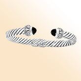 Handcrafted sterling silver cable cuff bracelet with black onyx and Balinese scrollwork details, bold artisan statement jewelry.